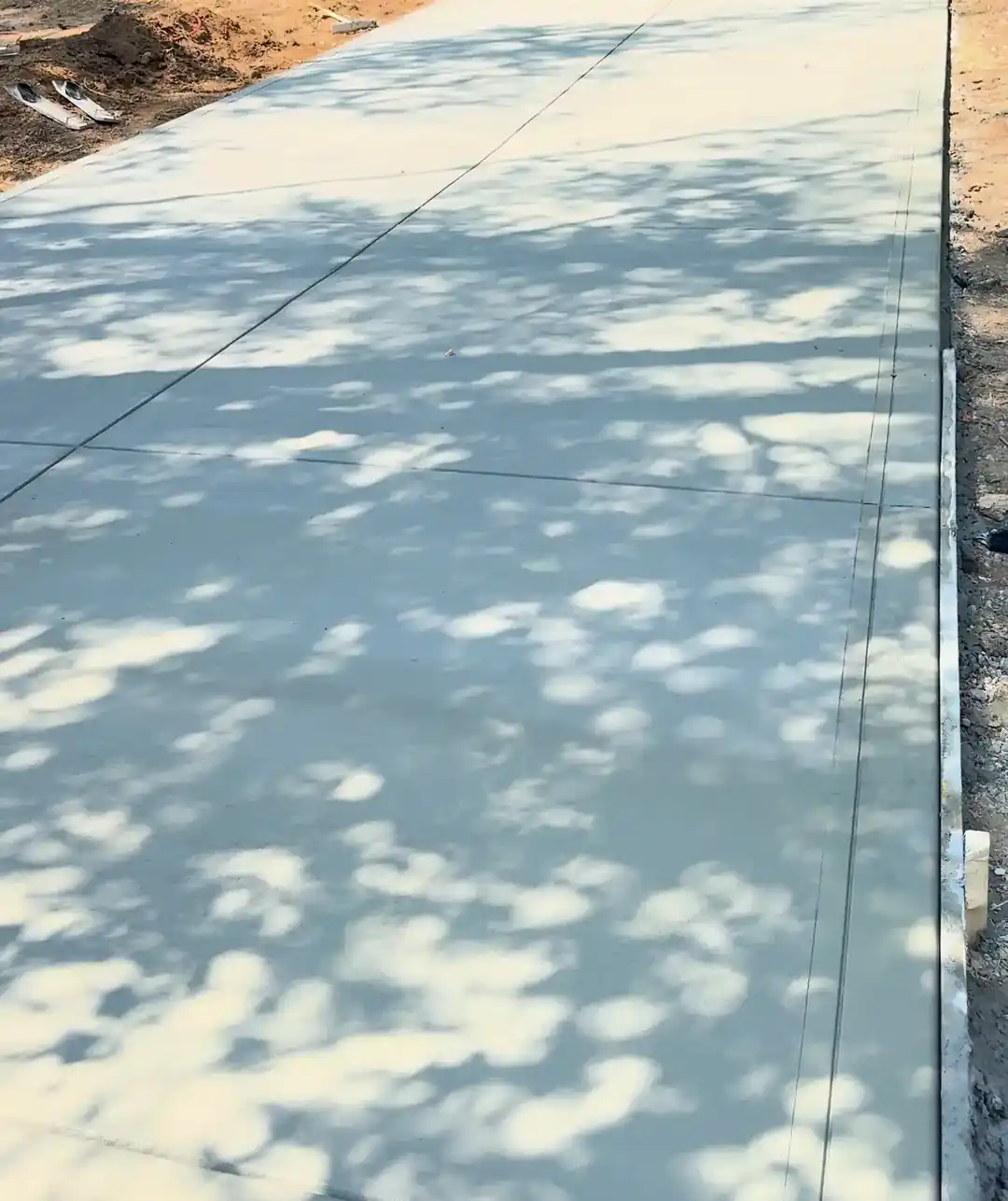 New concrete driveway in dappled shade in Charlotte