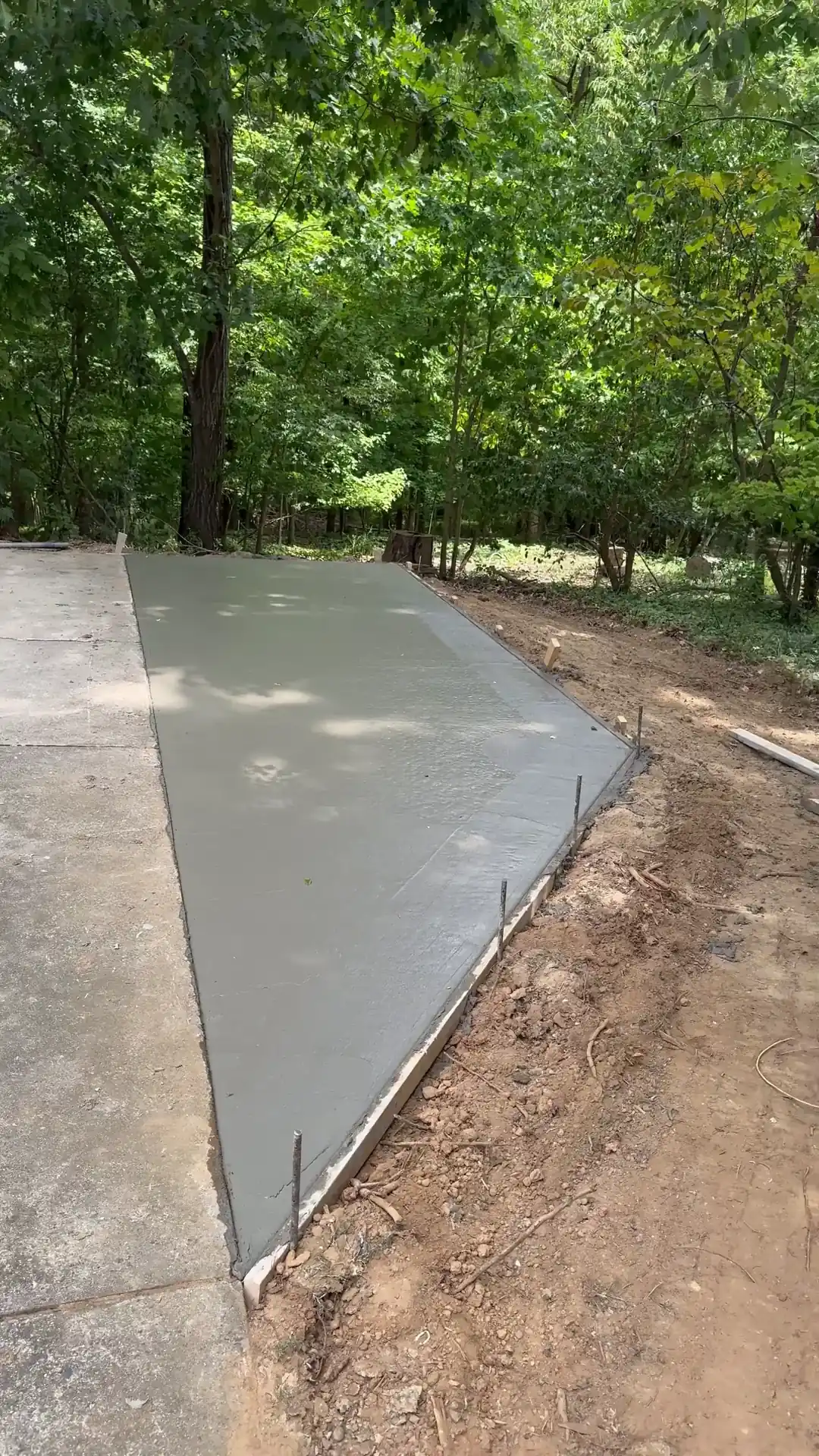 Freshly poured concrete driveway extension with the forms still on in Charlotte