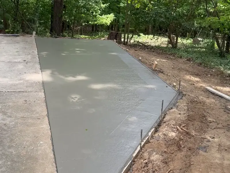 Freshly poured concrete driveway extension with the forms still on in Charlotte