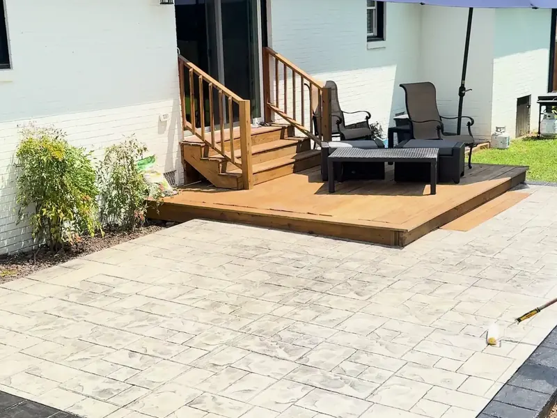 Stamped concrete patio with a charcoal border behind a house in Charlotte
