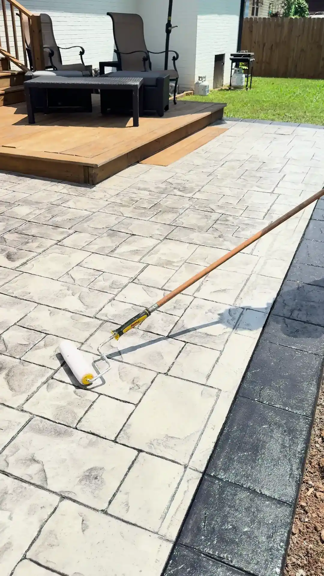 Close-up of a stamped concrete pattern on a Charlotte patio while sealer goes on