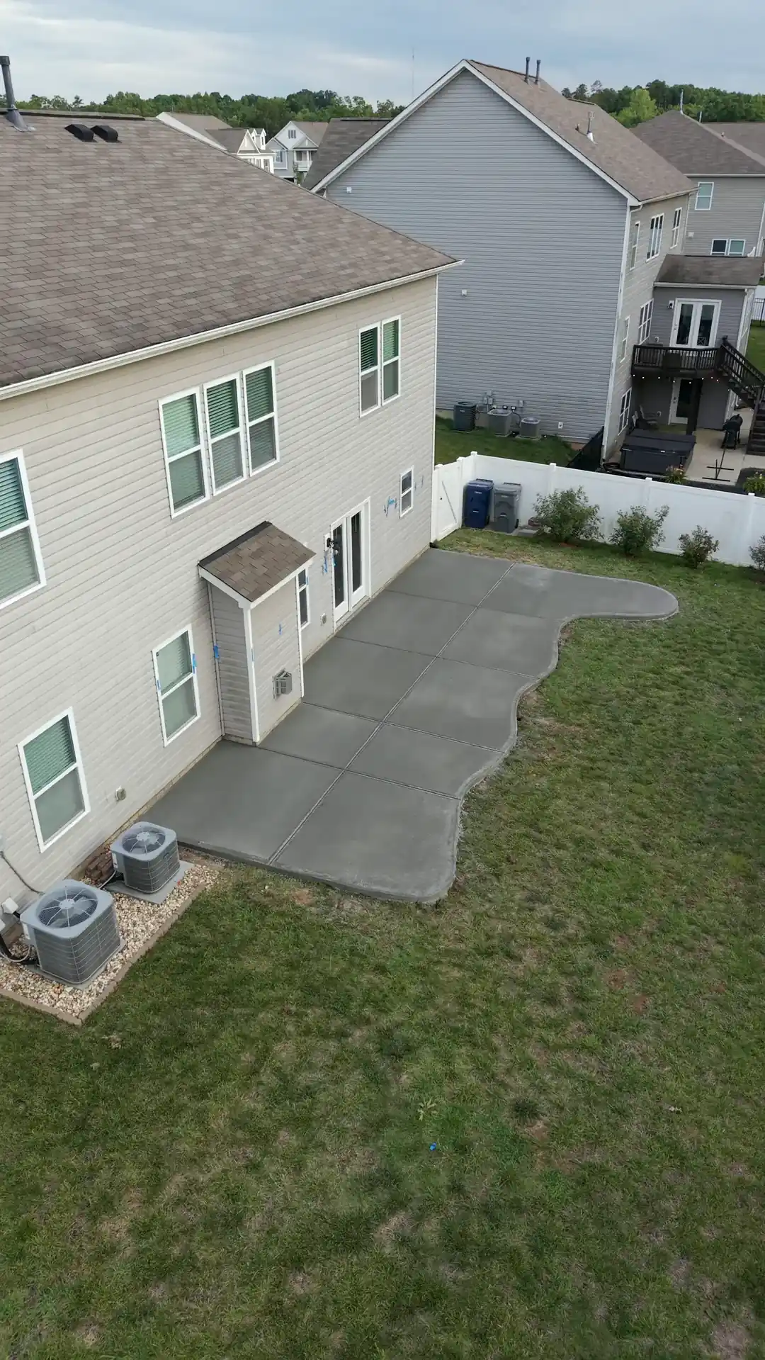 Curved backyard concrete patio behind a house in Harrisburg, seen from above