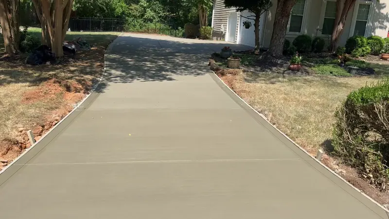 Finished broom-finish concrete driveway in Huntersville, seen from the yard