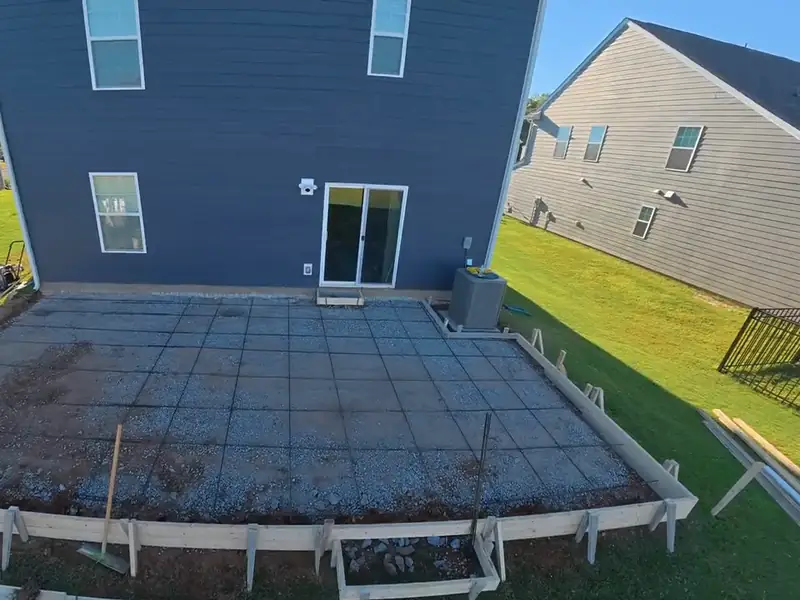 Backyard concrete patio replacement formed and ready to pour behind a two-story home